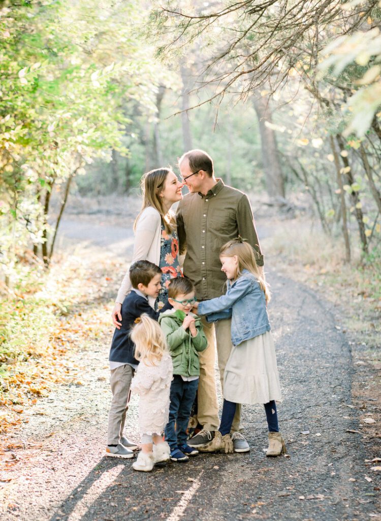 Intimate family photos, standing on the trail in the park, sunset peaking through the trees