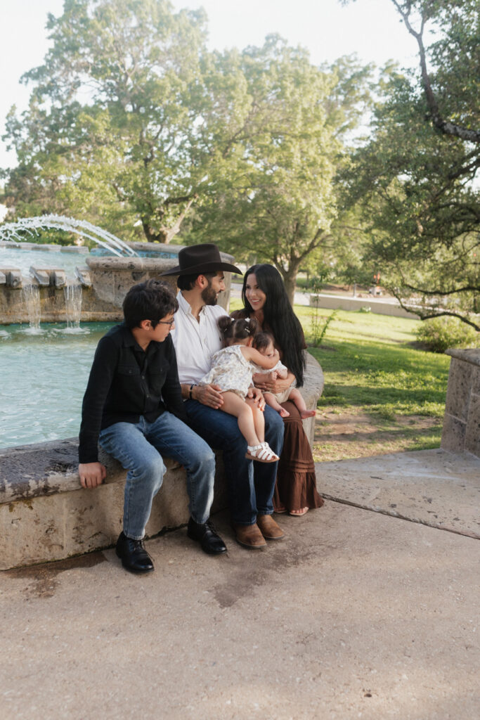 Familysitting in front of the fountain, babies hugging