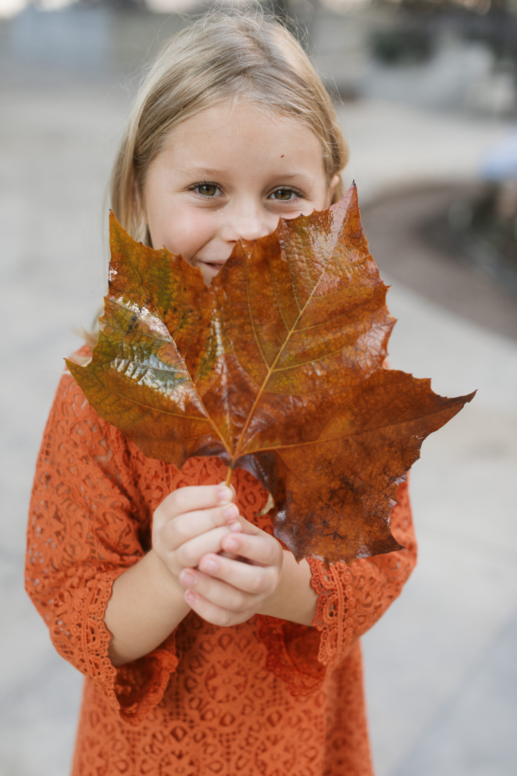 girl peaks over leaf