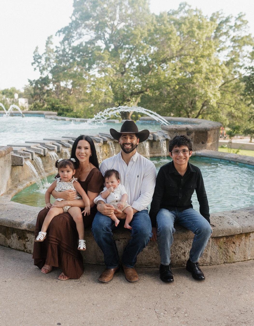 Cute Family sitting in front of the fountain taking Family Photos at the McNay Museum