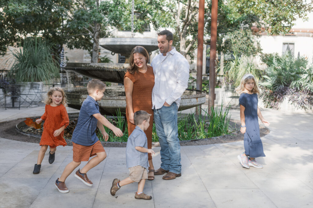 Military family with little kids laughing and playing in front of the fountain at The Pearl in San Antonio